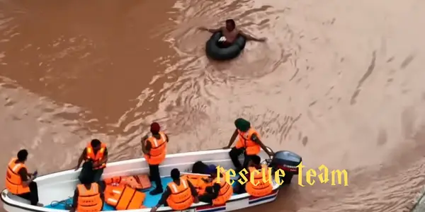 Rescue team evacuating stranded residents through floodwater